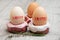 Easter concept. Three donut-shaped handmade ceramic egg holders or cups isolated on grey background.