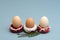 Easter concept. Three donut-shaped handmade ceramic egg holders or cups isolated on grey background.