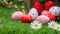 Easter concept. White daisies on green grass, blurred easter eggs background. Selective focus on the flowers