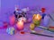 Easter decor, painted eggs, paints, brushes, lighted pink candles on a lilac background, preparation for the Easter holiday