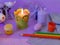 Easter decor, painted eggs, paints, brushes, lighted pink candles on a lilac background, preparation for the Easter holiday