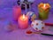 Easter decor, painted eggs, paints, brushes, lighted pink candles on a lilac background, preparation for the Easter holiday