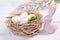 Easter decor with speckled eggs, nest and flowers and bunny