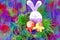 Easter decoration: yellow eggs and hand made festive plastic foam bunny in green grass twigs nest on purple background with boke