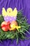 Easter decoration: yellow eggs and hand made hatched chicken in eggshell in green grass twigs nest on purple background
