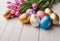 Easter decorations, colorfully painted and decorated Easter eggs and spring flowers on a wood background