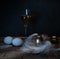 Easter. Easter night. Golden and White eggs, glass of wine, feathers on a wooden table. Vintage. Dark background