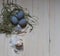 Easter egg with easter bunnies and three grey eggs in green shavings and white feathers on a light background