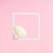 Easter egg made of delicate white gypsophila flowers on a white photo square frame and pastel pink background. Creative bright
