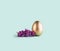 Easter egg painted in gold color decorated with purple lilac floewrs. Happy Easter minimalistic background