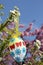 Easter egg with paper flowers, hanging in a shrub