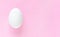 Easter egg on pastel pink background with copy space for text