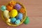 Easter eggs in a basket, straw, wooden colored space