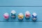 Easter eggs with color spotted small bows on the blue colored wooden background