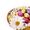 Easter eggs, colorful chocolate eggs with chamomile flower and pearl necklaces in basket