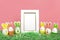 Easter eggs cute bunny, grass and white photoframe on coral pink backgroung. Funny decoration. Happy Easter concept