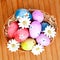 Easter eggs decorated with daisies tucked in a basket