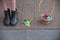 Easter eggs and female feet in boots on asphalt background