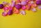 Easter eggs and flowers made of paper on a yellow background. The colors are pink, burgundy, fuchsia and yellow. Spring.