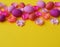 Easter eggs and flowers made of paper on a yellow background. The colors are pink, burgundy, fuchsia and yellow. Spring.