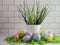 Easter eggs and green grass in a white bucket.  Indoor Easter and spring decor, against a white subway tile background,  Festive