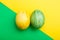 Easter Eggs on green and yellow geometric background. Yellow and green egg handmade new style of colouring on a colored cardboard.