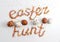 Easter eggs hunt phrase made from colorful baking sugar and row of eggs