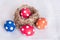 Easter eggs near birds nest on checkered white background