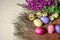 Easter eggs near the bouquet of wild flowers and dried buds of roses