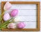 Easter eggs, photo frame, tulips on a white wooden background