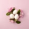 Easter eggs and pink flowers on white background. Easter nest. Flat lay, top view, concept of spring, femininity and beauty.