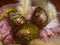 Easter eggs in a pink gift box with feathers, Easter decoration. Nest with golden red eggs on festive red background with glitters