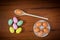 Easter eggs on plate, wooden spoon and loose on table