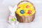 Easter eggs on pompom in basket and toy rabbit on checkered whi