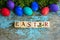 Easter eggs on rural blue moss background. wooden letters