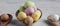 Easter eggs - speckled and sugar coated on wooden and silver spoons on white rustic wooden table. Closeup with shallow depth of f