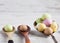 Easter eggs - speckled and sugar coated on wooden and silver spoons on white rustic wooden table. Closeup with shallow depth of f