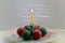 Easter eggs stacked around a candle on a plate