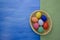 Easter eggs in yello basket on blue and fabric backgrounds S1V1