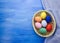 Easter eggs in yello basket on blue and fabric backgrounds S1V10