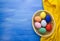 Easter eggs in yello basket on blue and fabric backgrounds S1V11