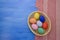 Easter eggs in yello basket on blue and fabric backgrounds S1V4