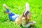 Easter feast concept. Cute child lay on grass with egg in hands. Child with cute bunny ears lying at meadow. Little girl