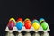 Easter festive multicolor eggs carton, black background