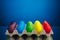 Easter festive multicolor eggs carton, blue background