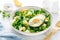 Easter fresh vegetable salad with boiled egg, broccoli, corn salad, green peas and avocado
