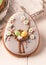 Easter gray cookie with decorative easter eggs and flowers near white cutting boards