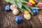 Easter. Hand made easter eggs and spring tulips on old wooden table