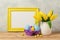 Easter holiday concept with tulip flowers, eggs decorations and blank photo frame