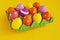 Easter holiday. Easter eggs in a tray for eggs. Eggs on a stand. Yellow background.